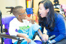 woman interacting with child in wheelchair