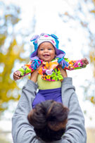 Parent holding up toddler with smiling face