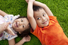 Asian siblings on grass