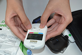 hand checking glucose levels on hand-held device