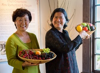 Asian couple carrying bowls of fruits and vegetables