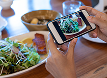 Hand of woman taking photo of meal with cellphone